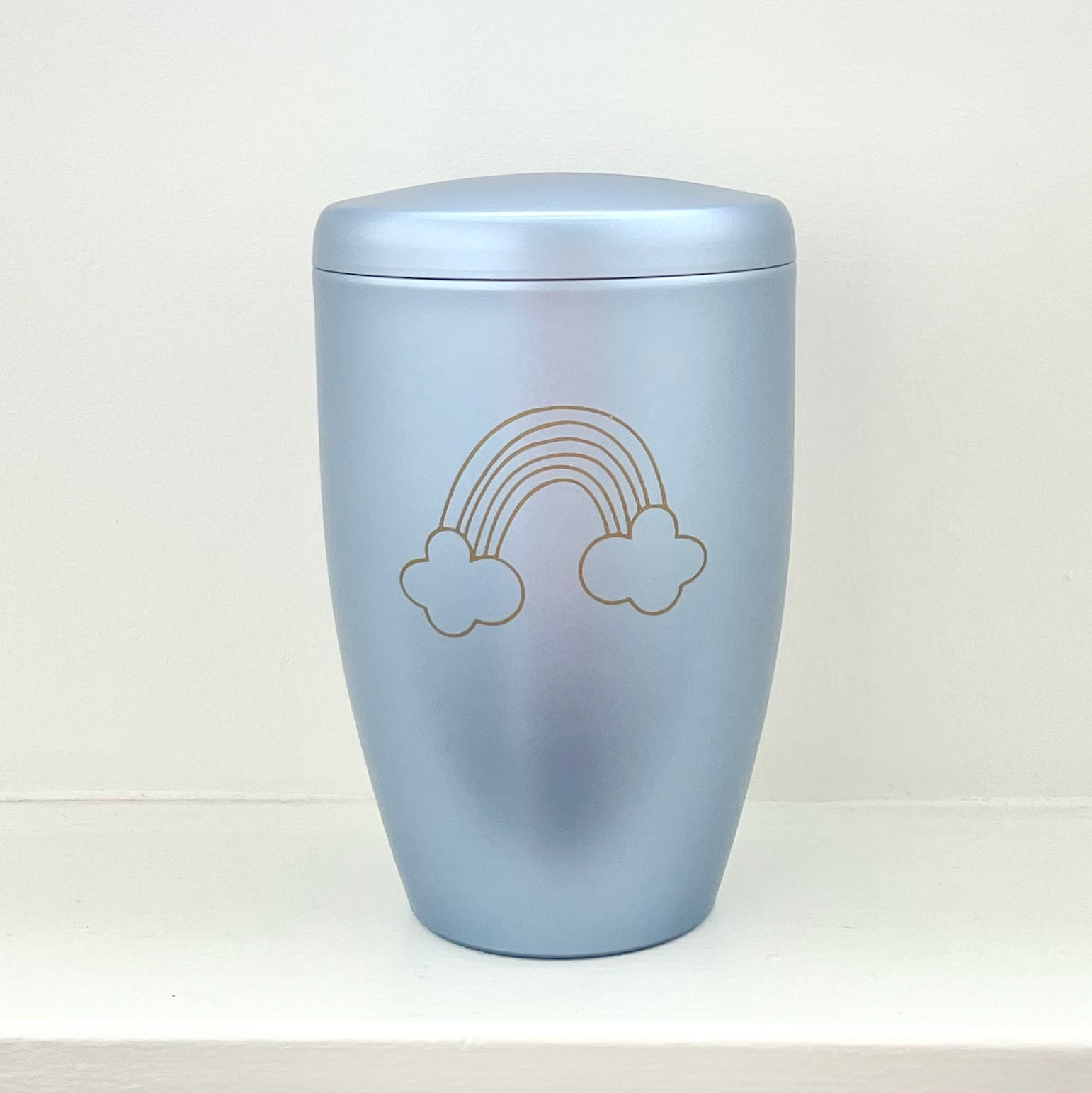Light blue infant urn with rainbow and clouds. Can be personalised with a name.