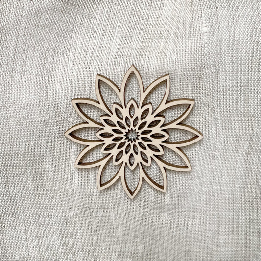 Close-up of wooden flower ornament on oatmeal coloured linen urn.