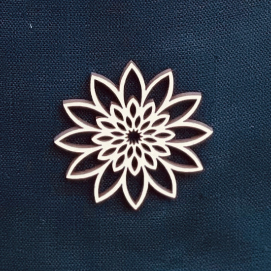 Close up of wooden ornament on a white linen cremation urn.