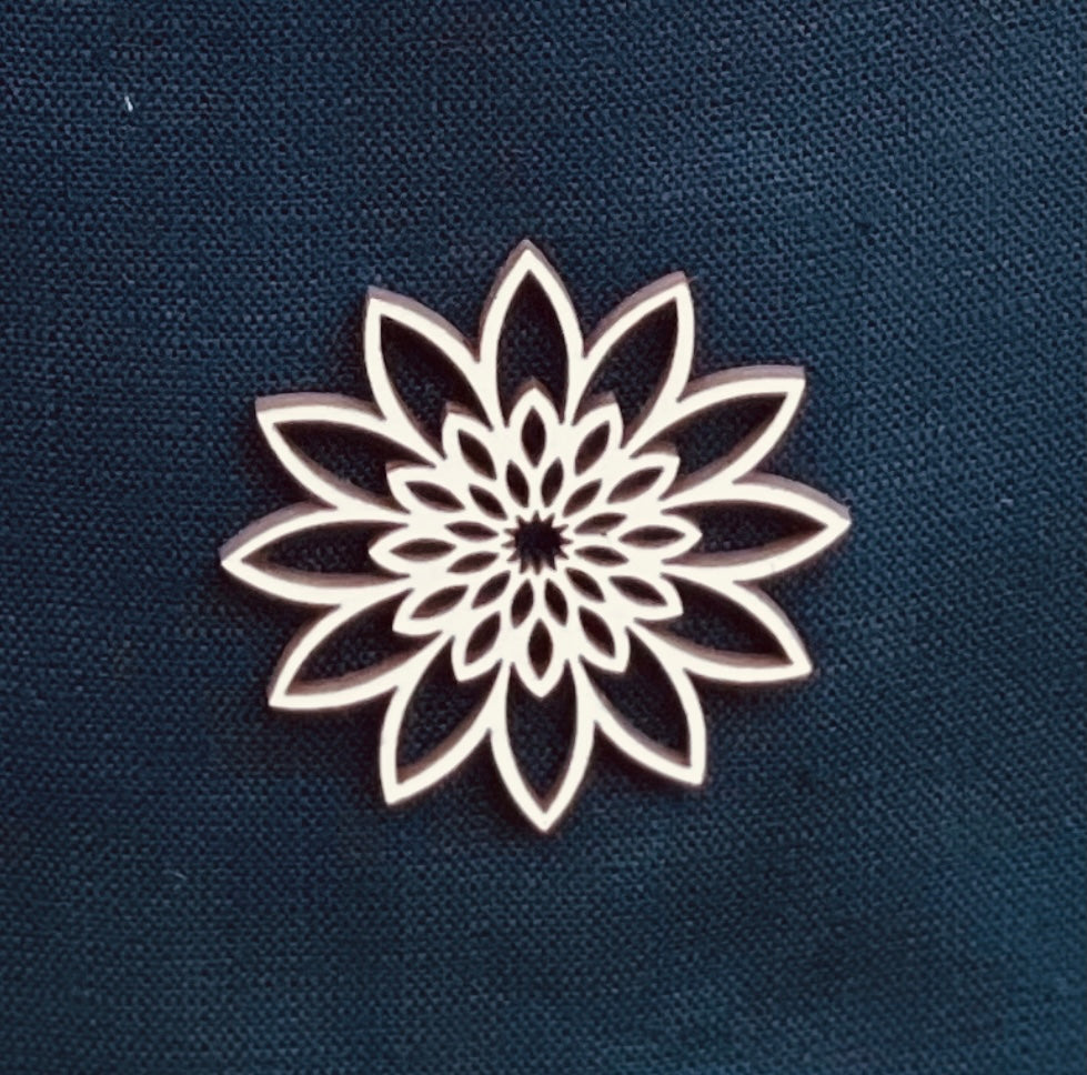 Close up of wooden ornament on a white linen cremation urn.