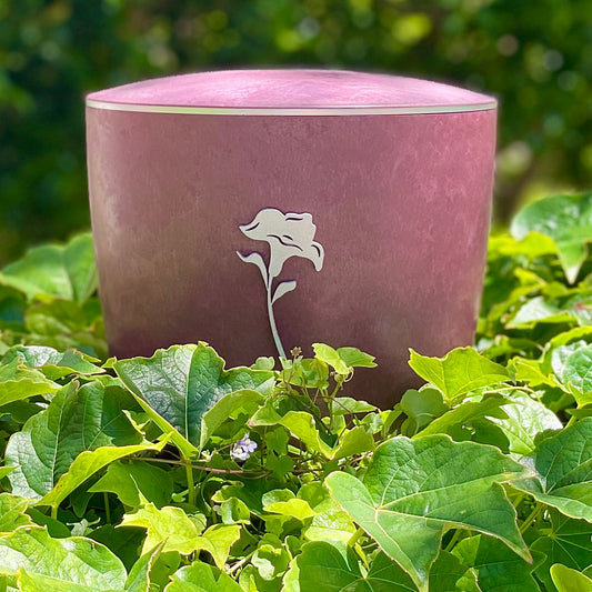 Stunning urn for ashes in a vibrant rose colour and a delicate 3mm silver decorative ring in a sea of ivy and forget-me-nots.