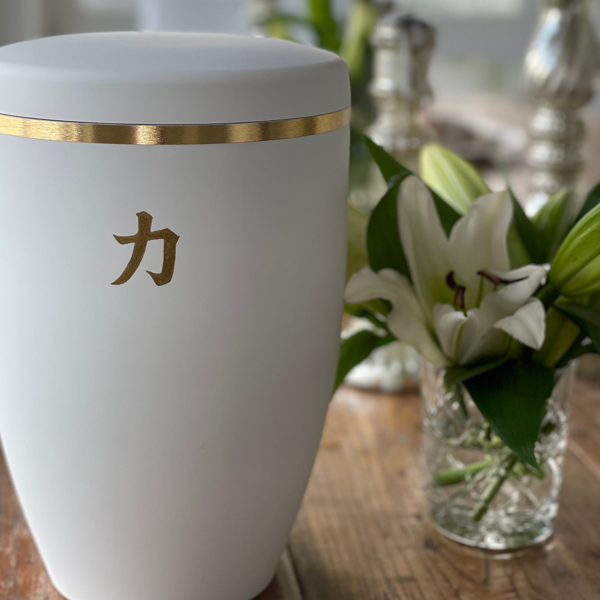 Beautiful white funeral urn with an elegant brushed gold band and customised with the golden japanese kanji letter for strength.